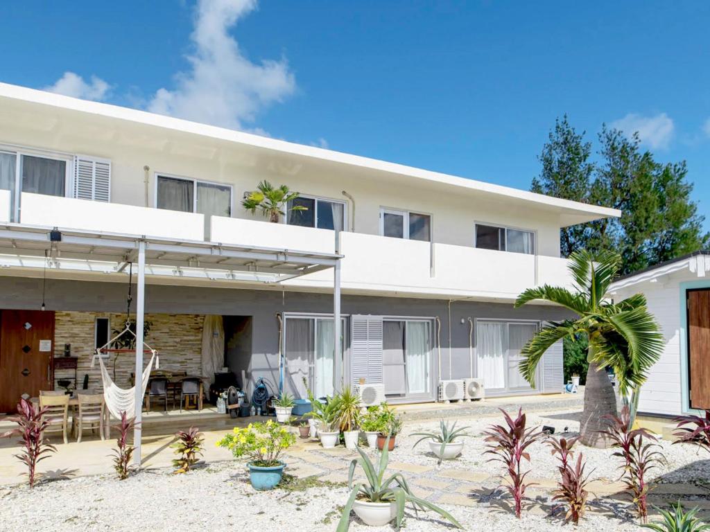an exterior view of a house with plants at GuesthouseKAZE in Miyako-jima