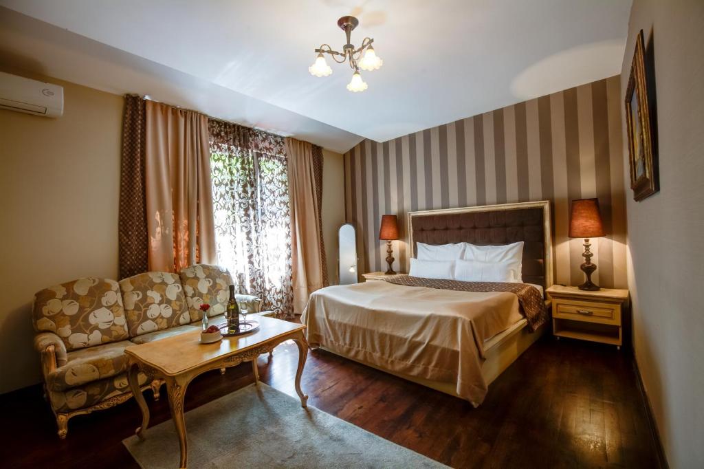 een hotelkamer met een bed en een bank bij Villa Skadarlija in Belgrado