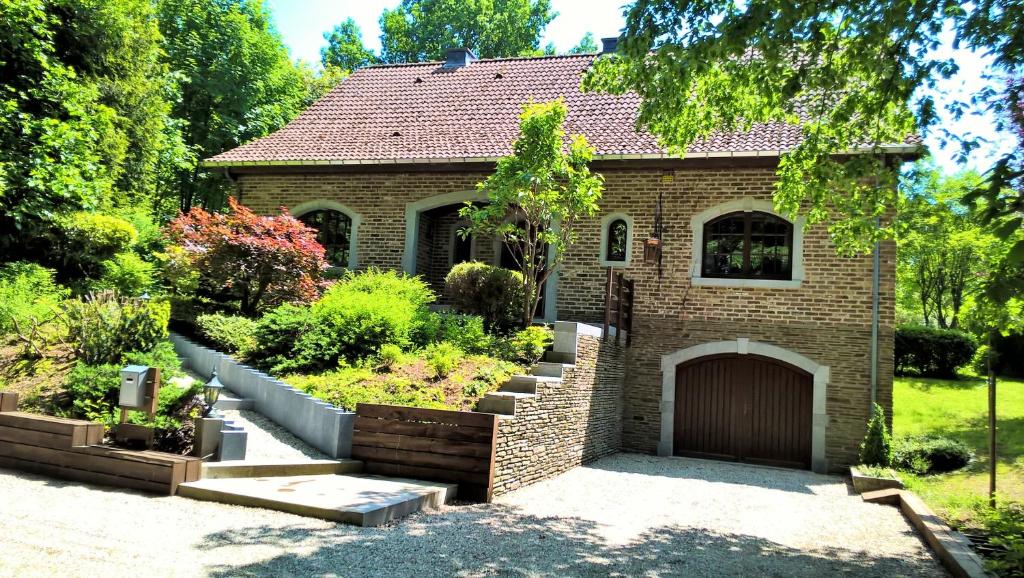 una casa de ladrillo con un jardín delante de ella en Villa Sous-Bois Marie, en Spa