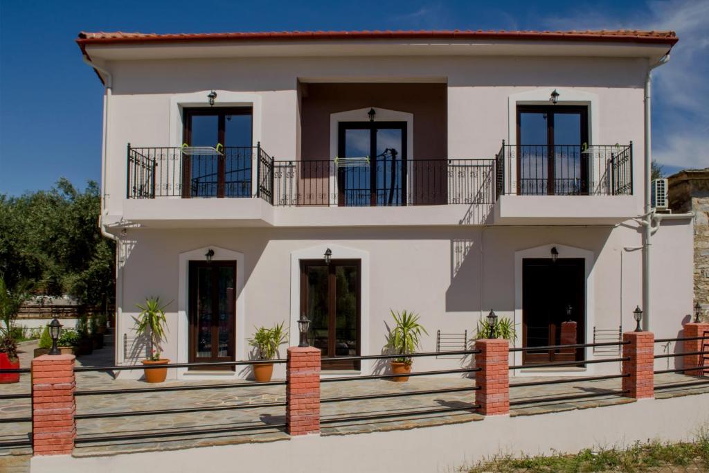 una grande casa bianca con un balcone di Serenity Studios a Kala Nera
