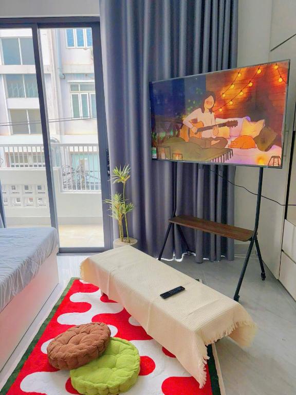a living room with a flat screen tv on a table at Corgi House Central Nha Trang in Nha Trang