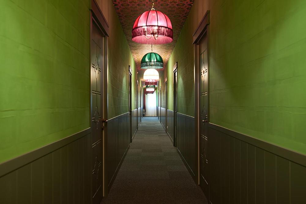 a hallway with green walls and a red chandelier at Бутик-Отель Старый Город in Chelyabinsk