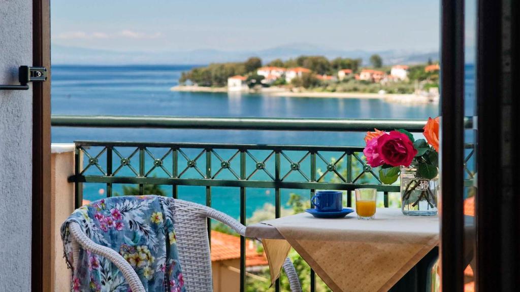 uma mesa com um vaso de flores numa varanda em Hotel Apartments Sikia em Kato Gatzea