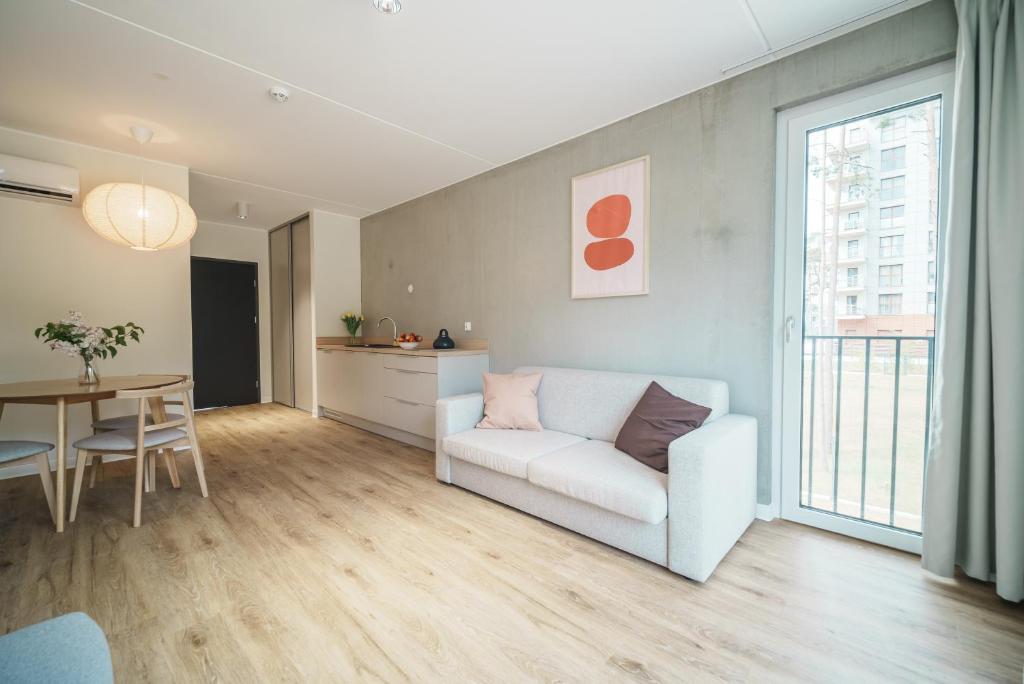 a living room with a white couch and a table at NA WYDMIE Apartments&Camp in Dziwnówek