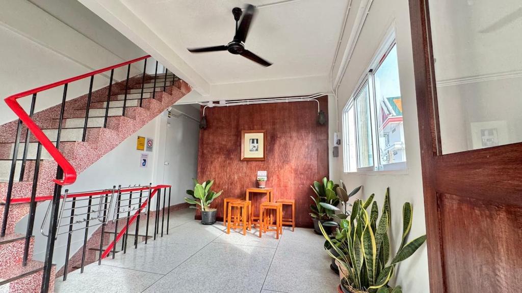 Un pasillo con una escalera y una mesa y sillas. en Baan PadSeeEw - Rooftop Riverview 3rd floor, en Thonhuri