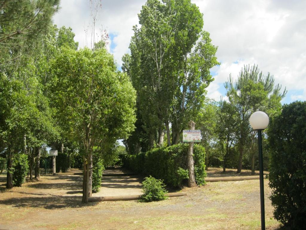 a park with trees and a street light at Camping Le Rebau in Montblanc