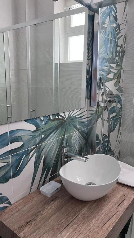 a bathroom with a sink and a large mirror at Appartamento I Delfini in Gabicce Mare