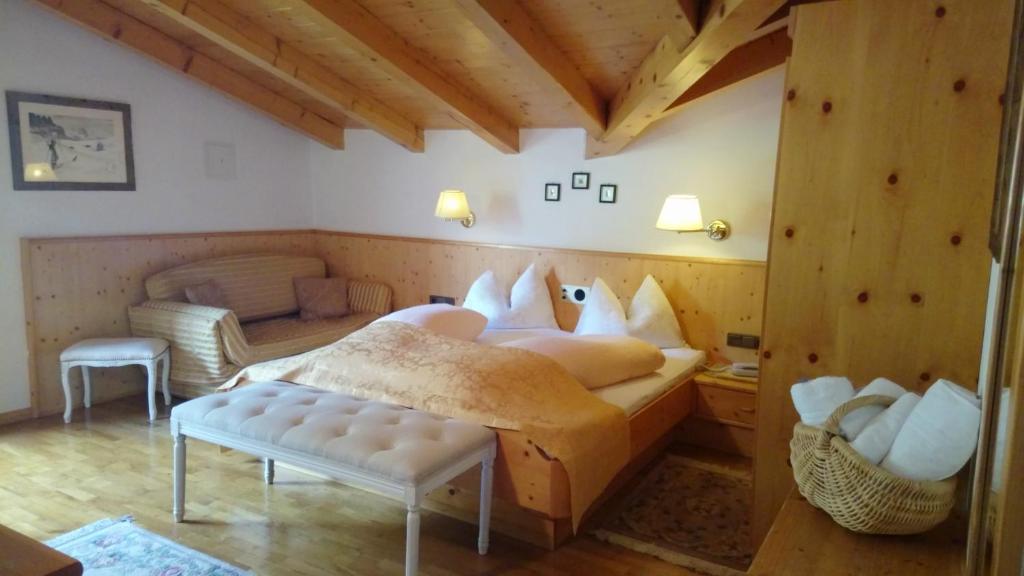 a bedroom with a bed in a room with wooden ceilings at Hotel Serena in Selva di Val Gardena