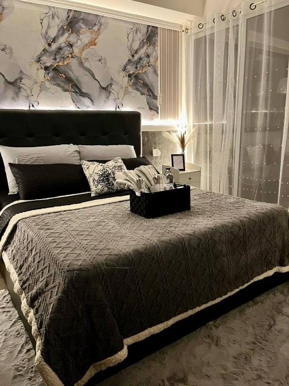 a bedroom with a large bed and a painting on the wall at Azure South by Dream Escapade in Manila