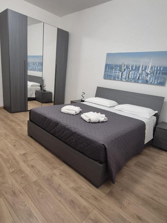 a bedroom with a large bed with two towels on it at Porto Antico Apartment in Genoa