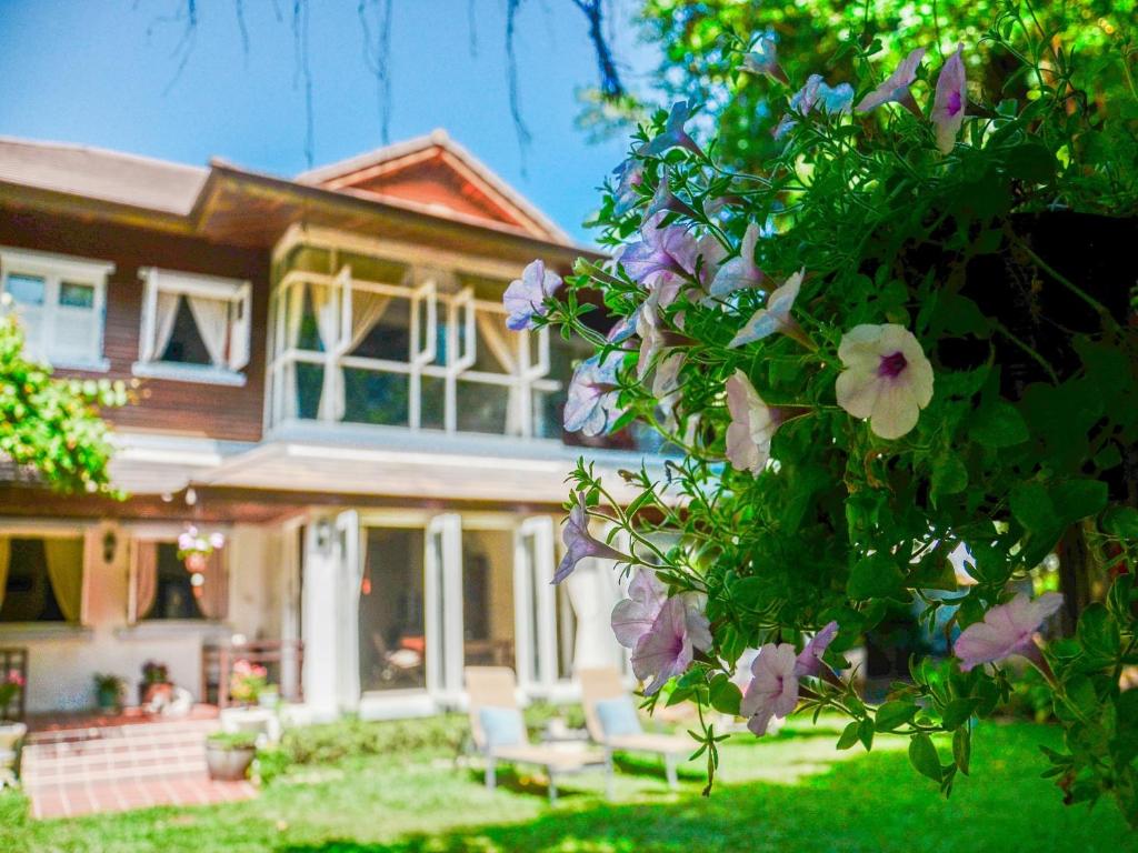 een huis met paarse bloemen ervoor bij Banyan House Samui bed and breakfast (Adult Only) in Chaweng Beach