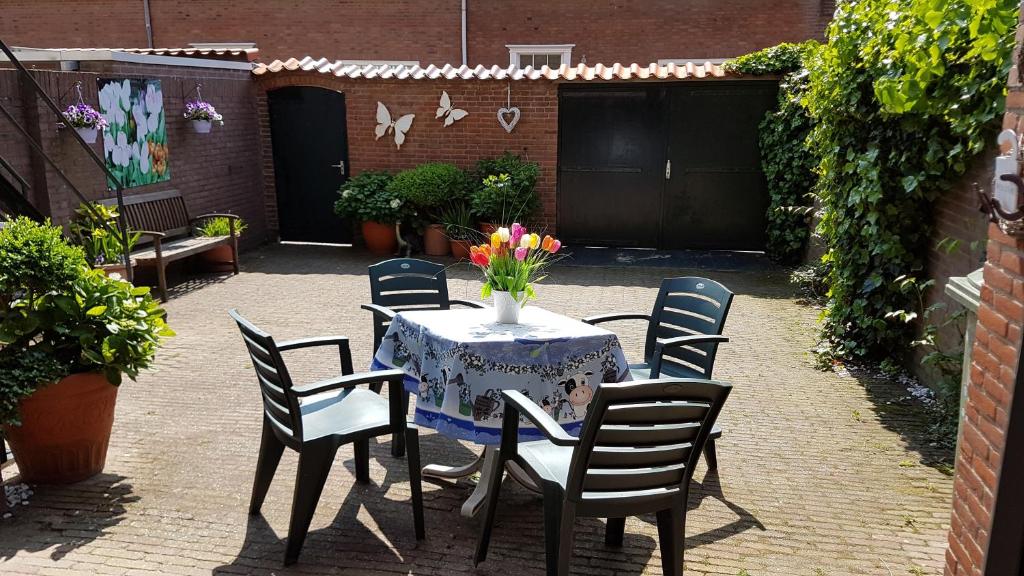 una mesa con sillas y un jarrón de flores. en Appartement in Zandvoort, en Zandvoort
