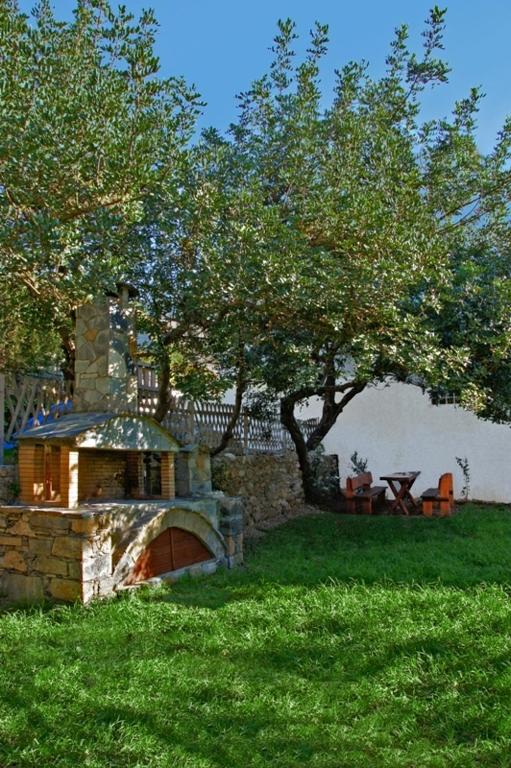 a stone bridge in a field with a tree at Aretousa in Sougia