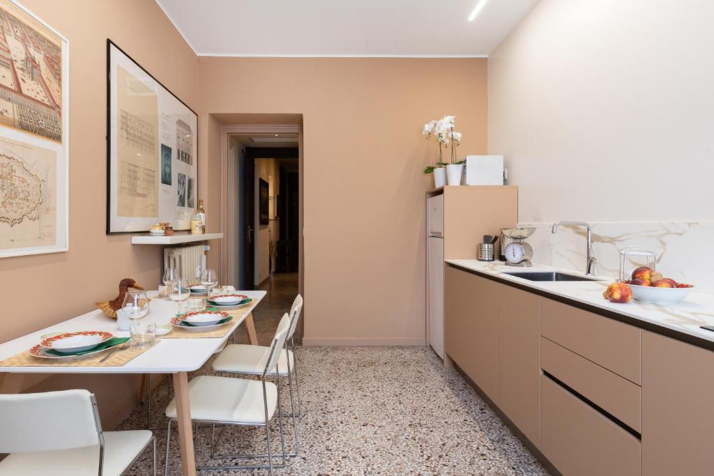 a kitchen with two tables and a counter and a sink at Eleganza sabauda 120 sqm Luxury historical flat in Turin