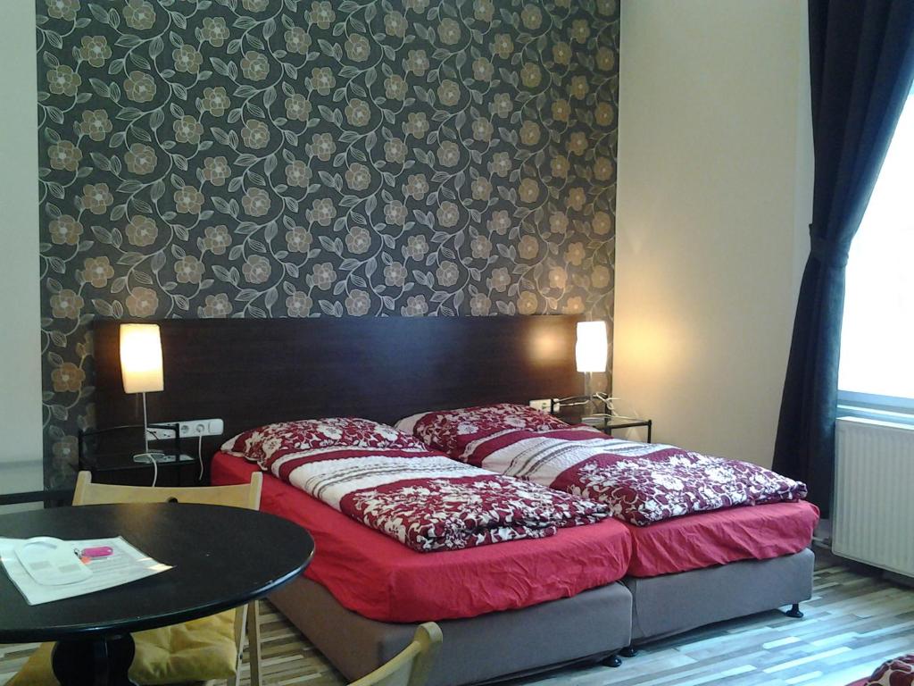 Liechtenstein Apartments في بودابست: سرير في غرفة مع طاولة وجدار