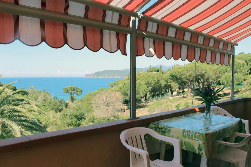 カポリーヴェリにあるCasa Robertaのテーブルと椅子、海の景色を望むバルコニー
