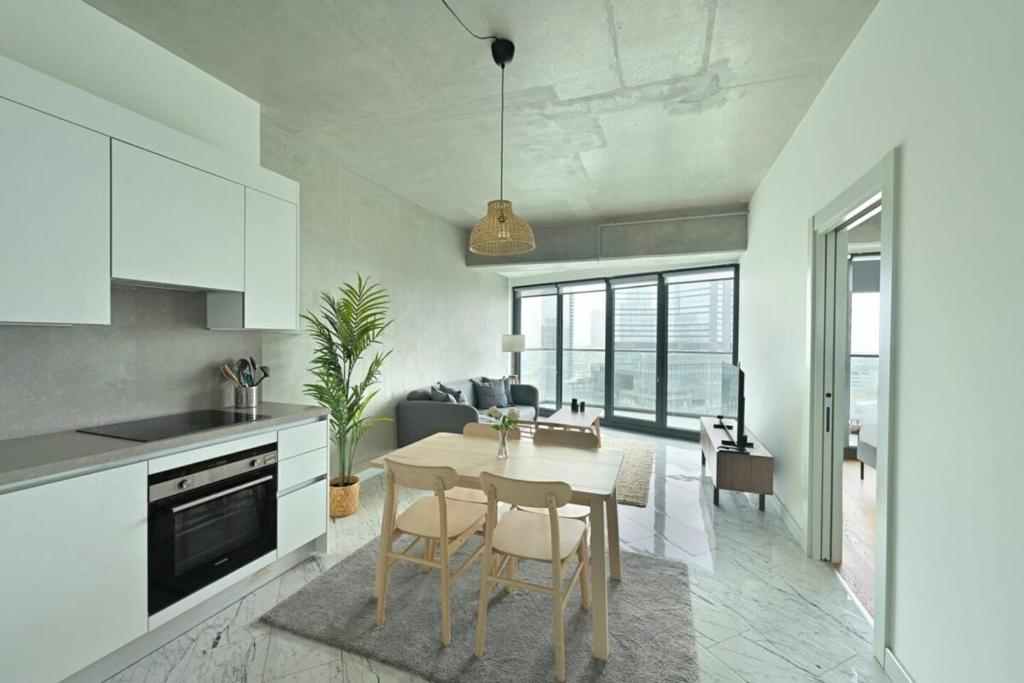 une cuisine et un salon avec une table et des chaises dans l'établissement Gorgeous Modern 1bd Terracepoolviews! #183, à Istanbul