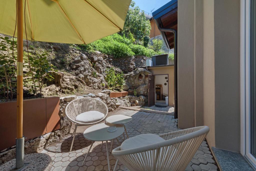 a patio with two chairs and an umbrella at Casa Teresa Suite in Como in Como