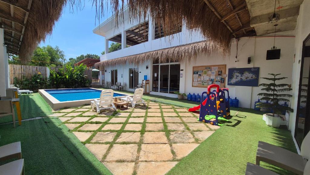 un patio trasero con piscina y un edificio en Camotes Hostel Resort, en Islas Camotes