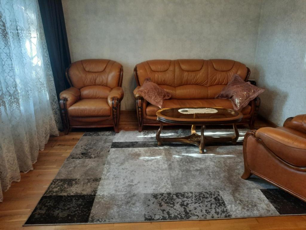 a living room with leather chairs and a table at Дом in Odesa