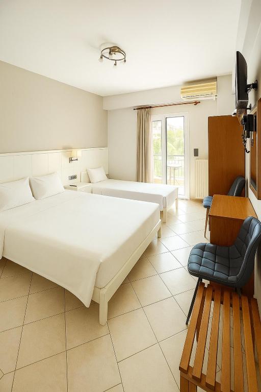 a hotel room with two beds and a chair at Paradosi Rooms in Igoumenitsa