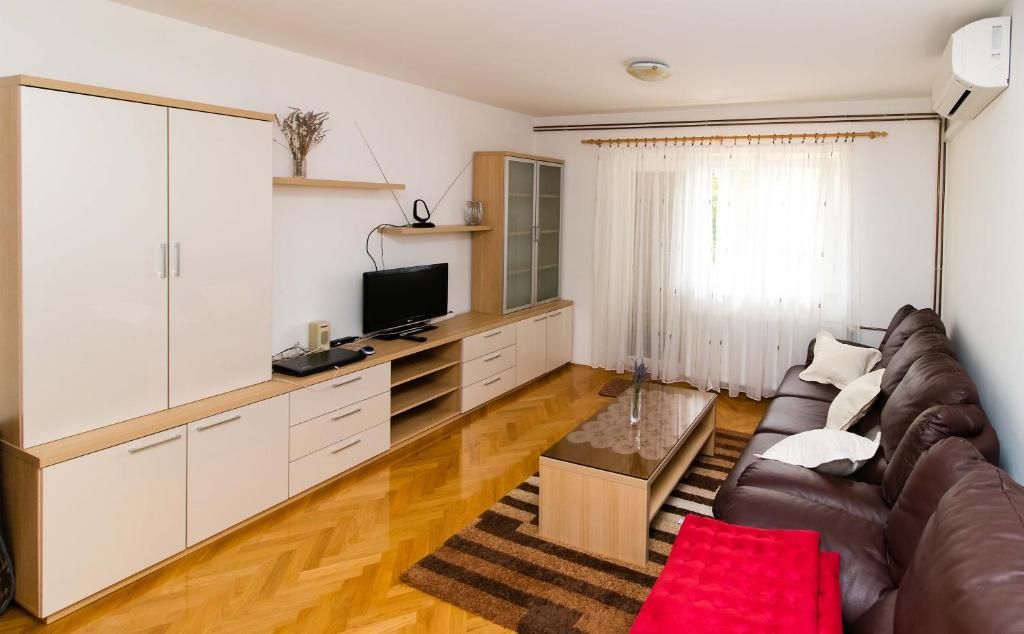 a living room with a couch and a tv at Apartment Peran in Šibenik