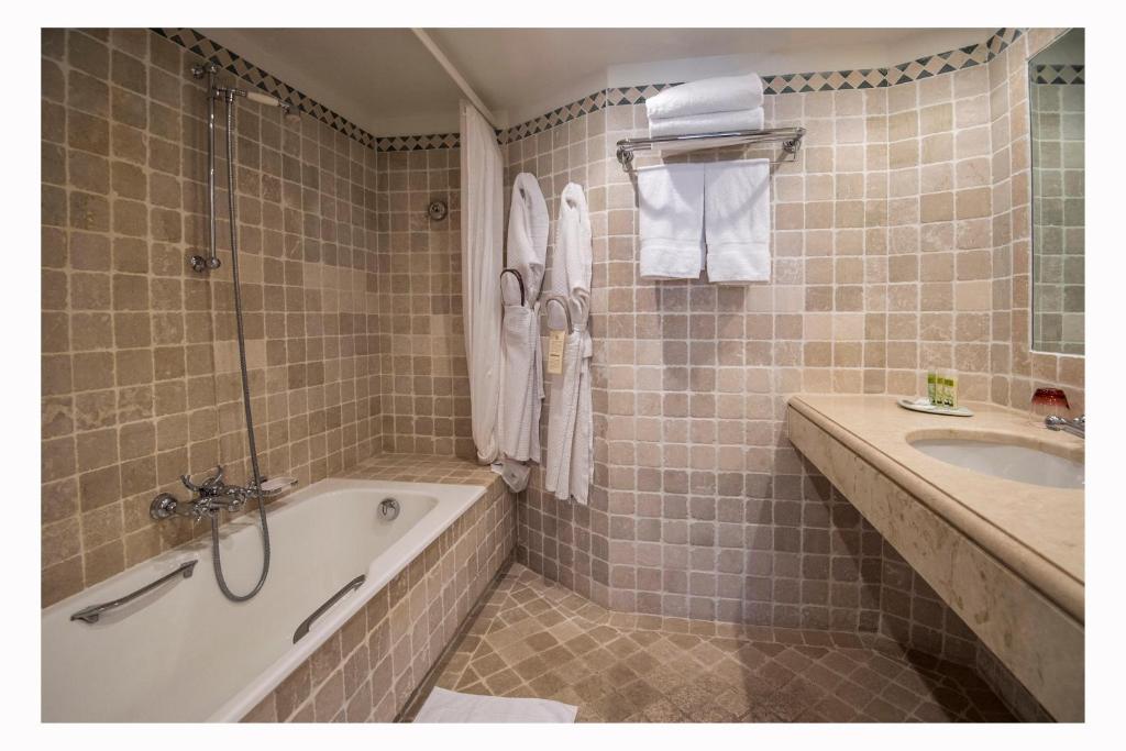 a bathroom with a tub and a sink at Hôtel La Pérouse Nice Baie des Anges in Nice