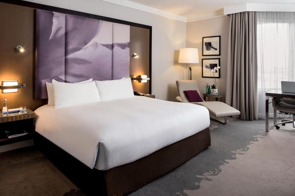 a hotel room with a large bed and a desk at Pullman Miami Airport in Miami