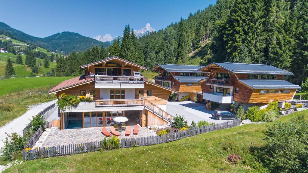 a house on a hill with mountains in the background at Alpin Chalet Filzmoos in Filzmoos
