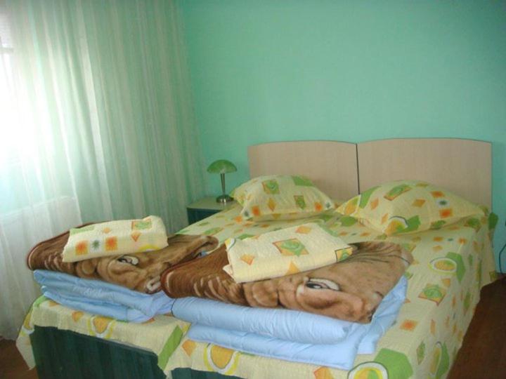 Una cama con manta y almohadas. en Pensiunea Vital, en Chilia Veche