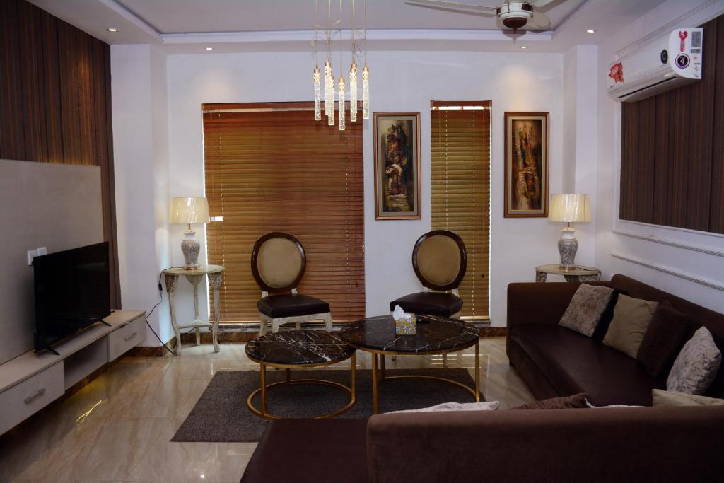 a living room with a couch and two chairs at 116 Apartments Luxestay CBD in Lahore