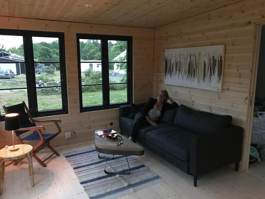 a woman sitting on a couch in a living room at Wonderful summer place in beautiful Köpingsvik, Borgholm in Köpingsvik