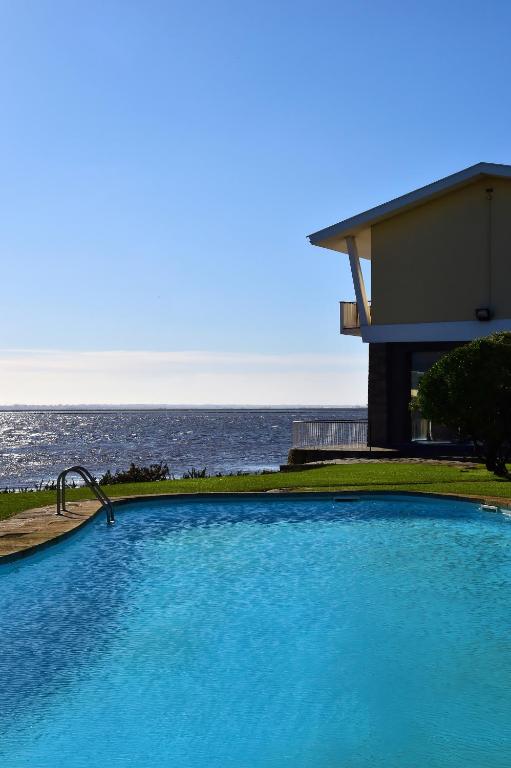 a large blue swimming pool next to the ocean at Pousada Ria - Aveiro in Torreira