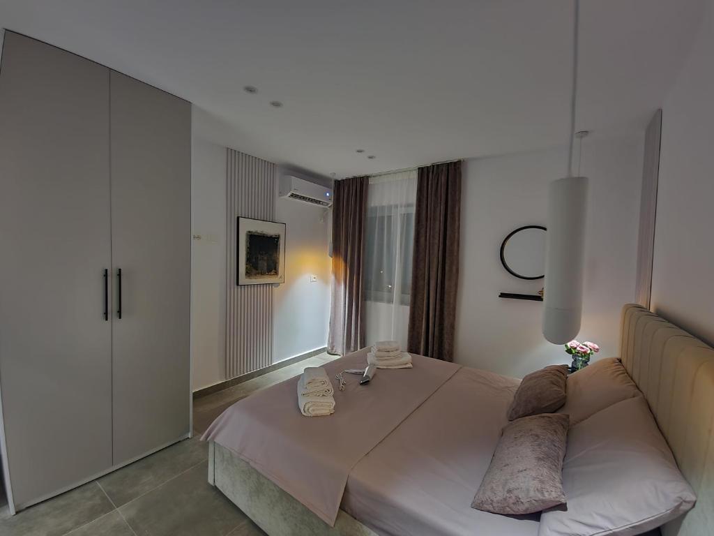 a bedroom with a white bed and a couch at Feel like home 2 in Shkodër