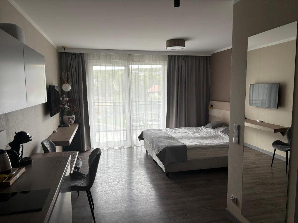 a hotel room with a bed and a living room at Apartament e310 - Bel Mare Międzyzdroje in Międzyzdroje