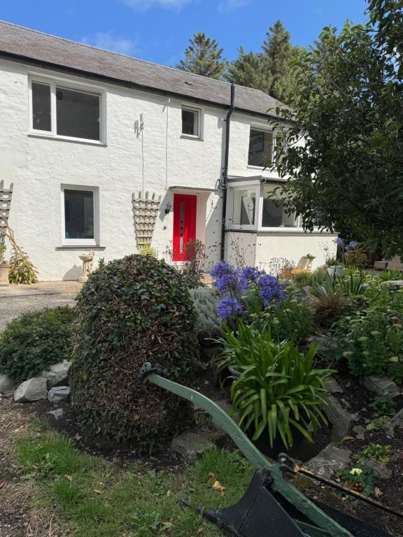 a house with a red door and a garden at Lower Milntown Farm in Ramsey