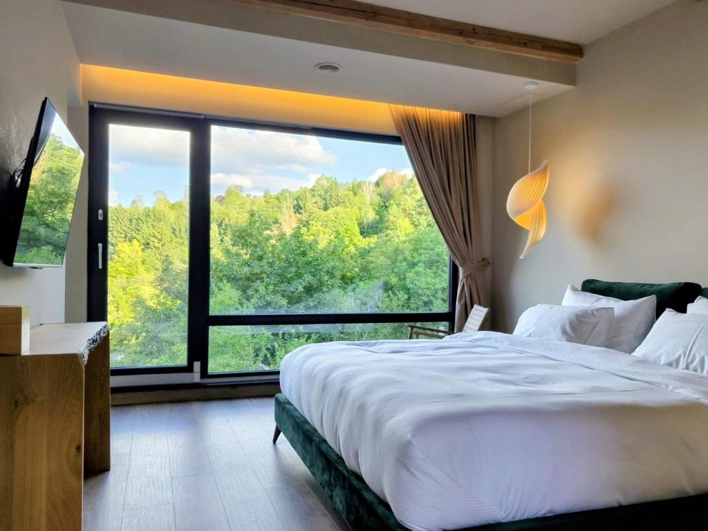 a bedroom with a large bed and a large window at Celest Boutique Urban Hideaway in Braşov