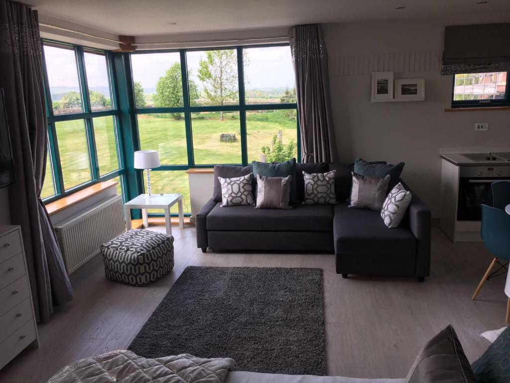 a living room with a couch and a large window at Penrith Retreats in Penrith