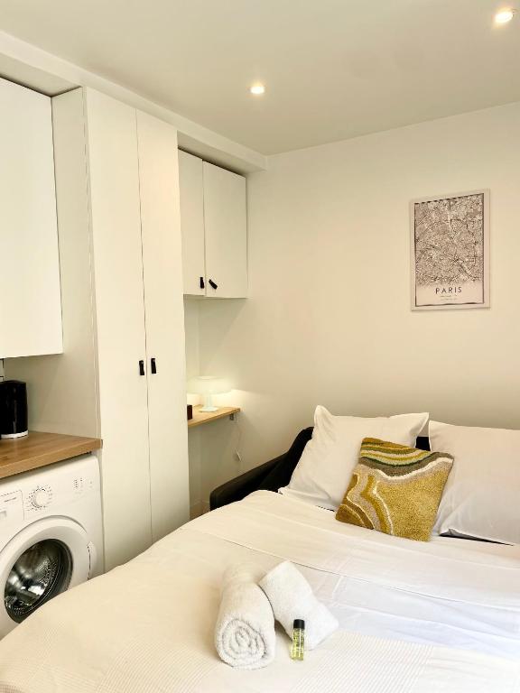 - une chambre avec un lit et un lave-linge dans l'établissement Charming & bright studio apartment Heart of Paris 2 Le Marais, à Paris