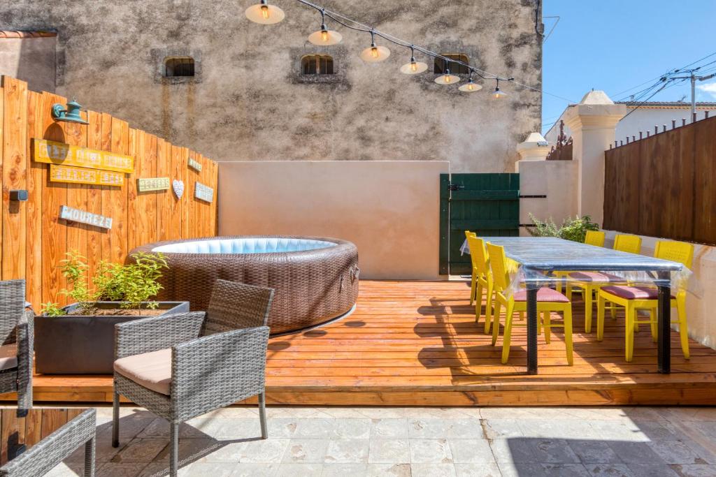 a patio with a table and chairs on a deck at Gîte A La Bonne Franck'ette in Aspiran
