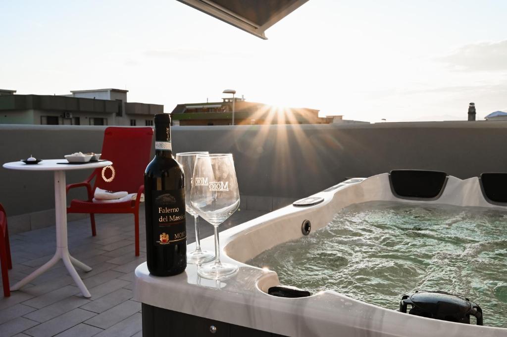 a bottle of wine and a wine glass in a hot tub at Dimora Domitia - Apartments in Mondragone