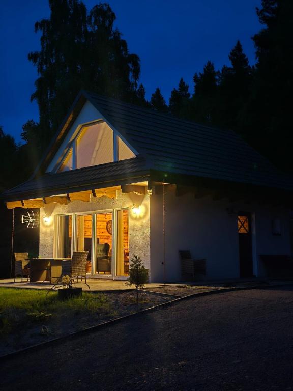 a house with lights on the side of it at night at Noclegi Panorama - Domek RUSTIC in Ustrzyki Dolne