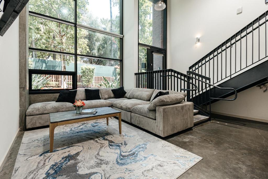 ein Wohnzimmer mit Sofa und Tisch in der Unterkunft Palm & Vine MODERN COZY LOFT in HOLLYWOOD, FREE Parking in Los Angeles