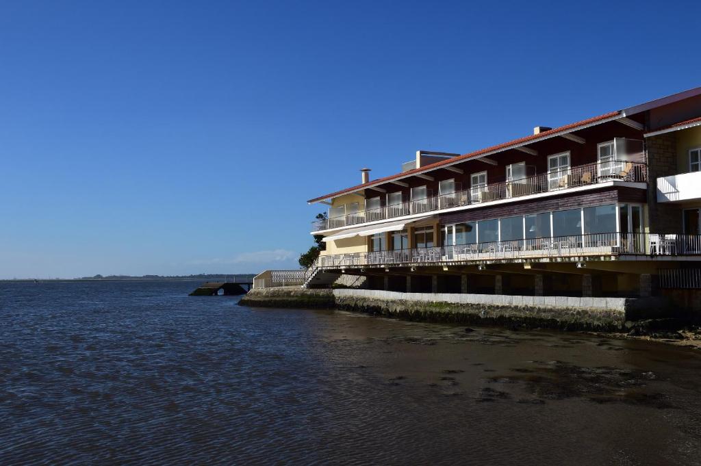 a hotel on the shore of a body of water at Pousada da Ria in Torreira