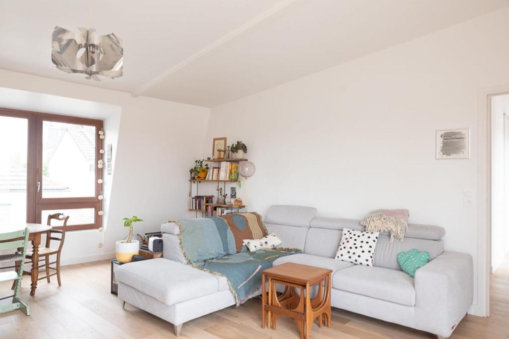 un salon avec un canapé et une table dans l'établissement T4 with balcony near Paris, à Pantin
