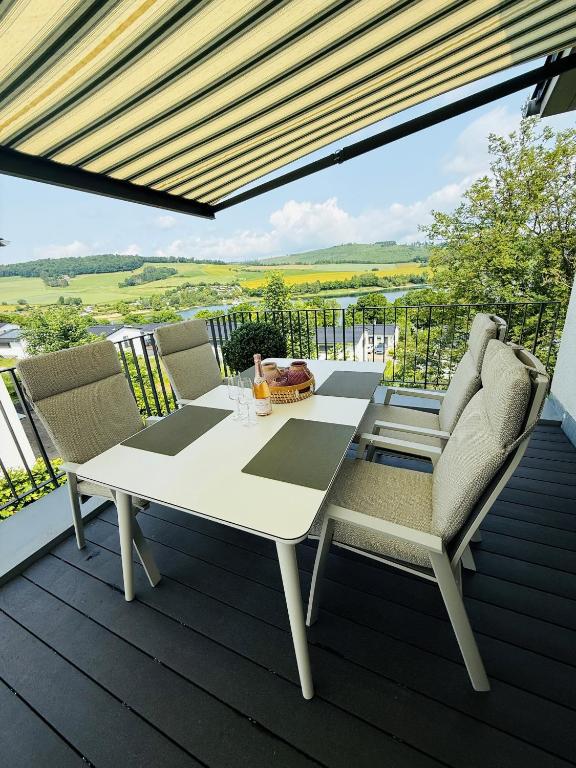 a white table and chairs on a deck with a view at Sonnenweg 4 in Diemelsee