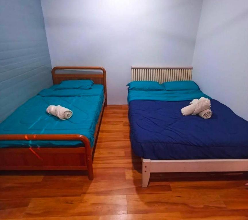- 2 lits dans une chambre avec des draps bleus dans l'établissement Qudwah Stay, 