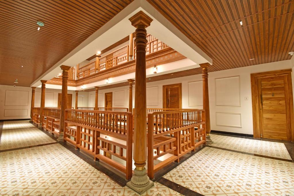 a large room with a balcony with a wooden ceiling at AKG Hotel in Pondicherry
