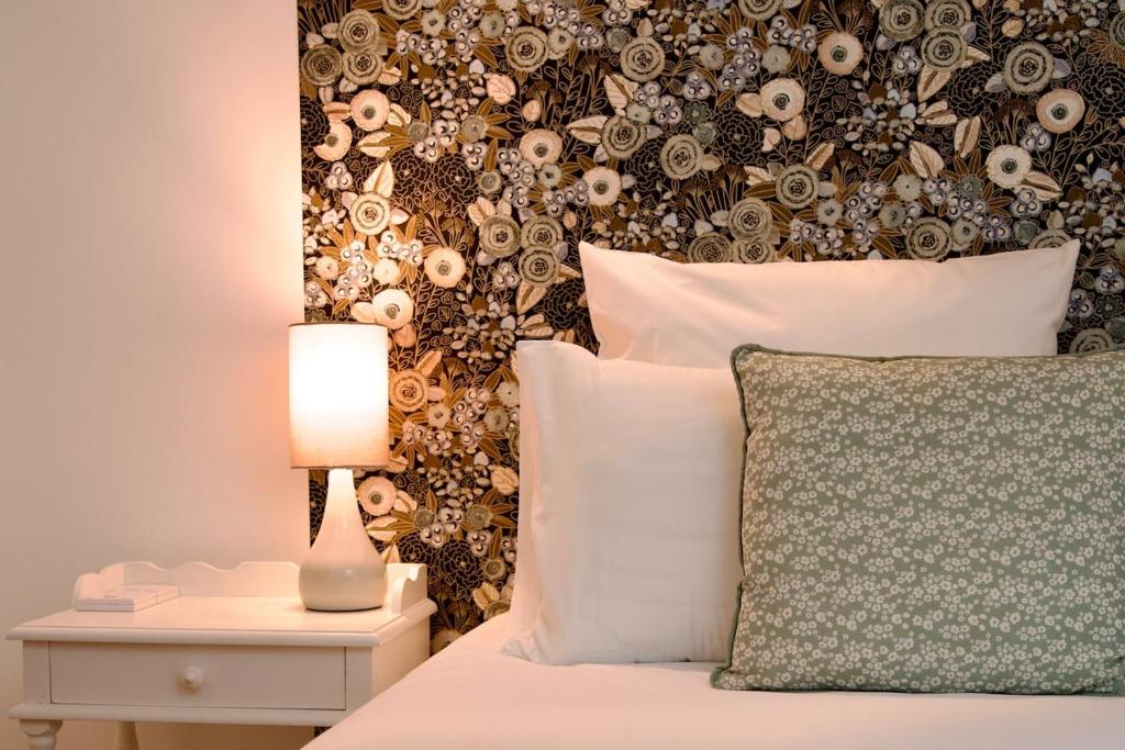 a bedroom with a bed with a floral wall at Le Familia in Guer