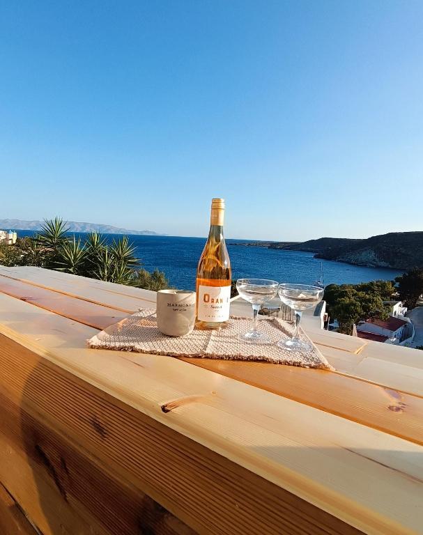 a bottle of wine sitting on a table with wine glasses at Kanala Sea View in Kanala